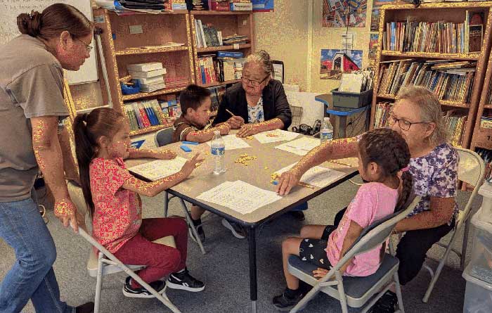 Table of three students and three adults working on math problems