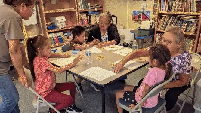 Table of three students and three adults working on math problems